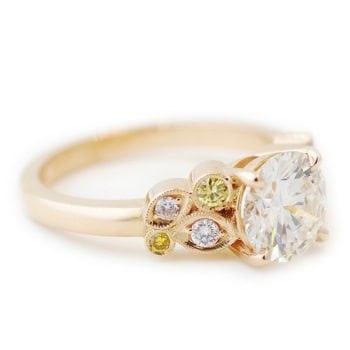 Right side profile and details of the The Mary, an engagement ring made of 14k rose gold, 1.31 carat diamond center stone, and pink and yellow diamond accents custom made by Abby Sparks Jewelry.