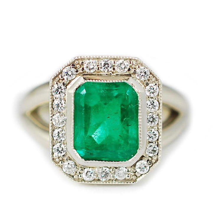 Unique push present custom ring made with 14k white gold, 2.18 carat emerald, and 0.20 ctw diamond melee halo custom made and designed by Abby Sparks Jewelry, The Erika.