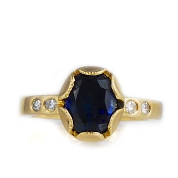 Custom engagement ring made with 14k yellow gold, 1.4 carat blue sapphire and 0.5 ctw diamond accents custom made and designed by Abby Sparks Jewelry, The Clara.