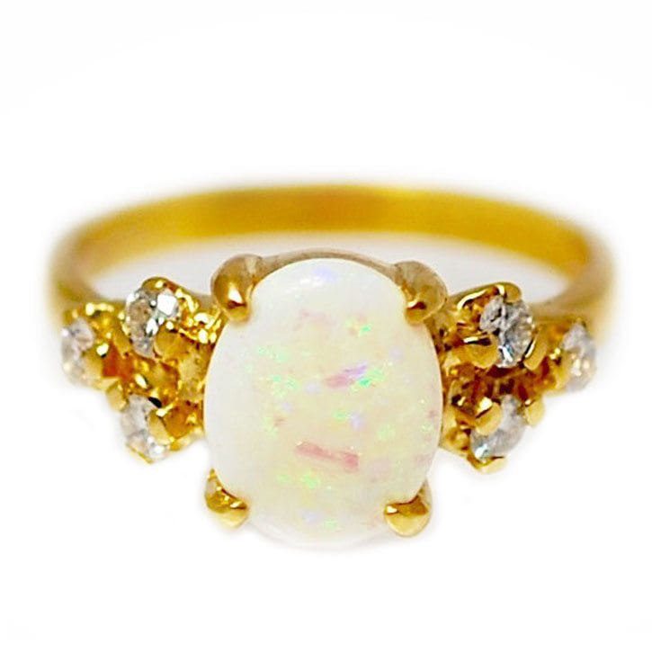 Custom handmade engagement ring made with 22k yellow gold, 1.0 carat opal center stone, and 0.3 ctw diamond accents made and designed by Abby Sparks Jewelry, The Gabbi.